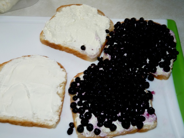 Press blueberries into two of the sandwich halves