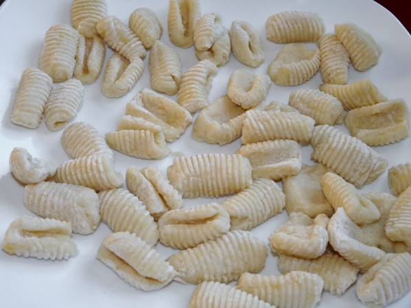 Use a fork or gnocchi board to roll indentions. Boil in salted water until they float. Remove and cool in a single layer.