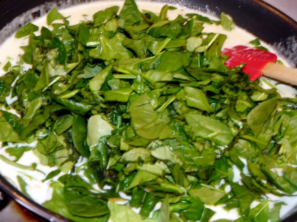 Stir in chopped spinach and cook until wilted, stirring occasionally. Set aside half of sauce in a bowl.